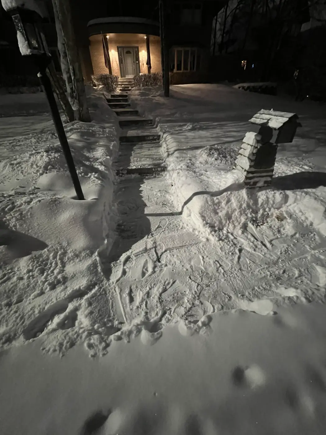 Snow removal Anchorage Alaska - snow-covered walkway leading to residential entrance with snow drifts and mailbox professional services